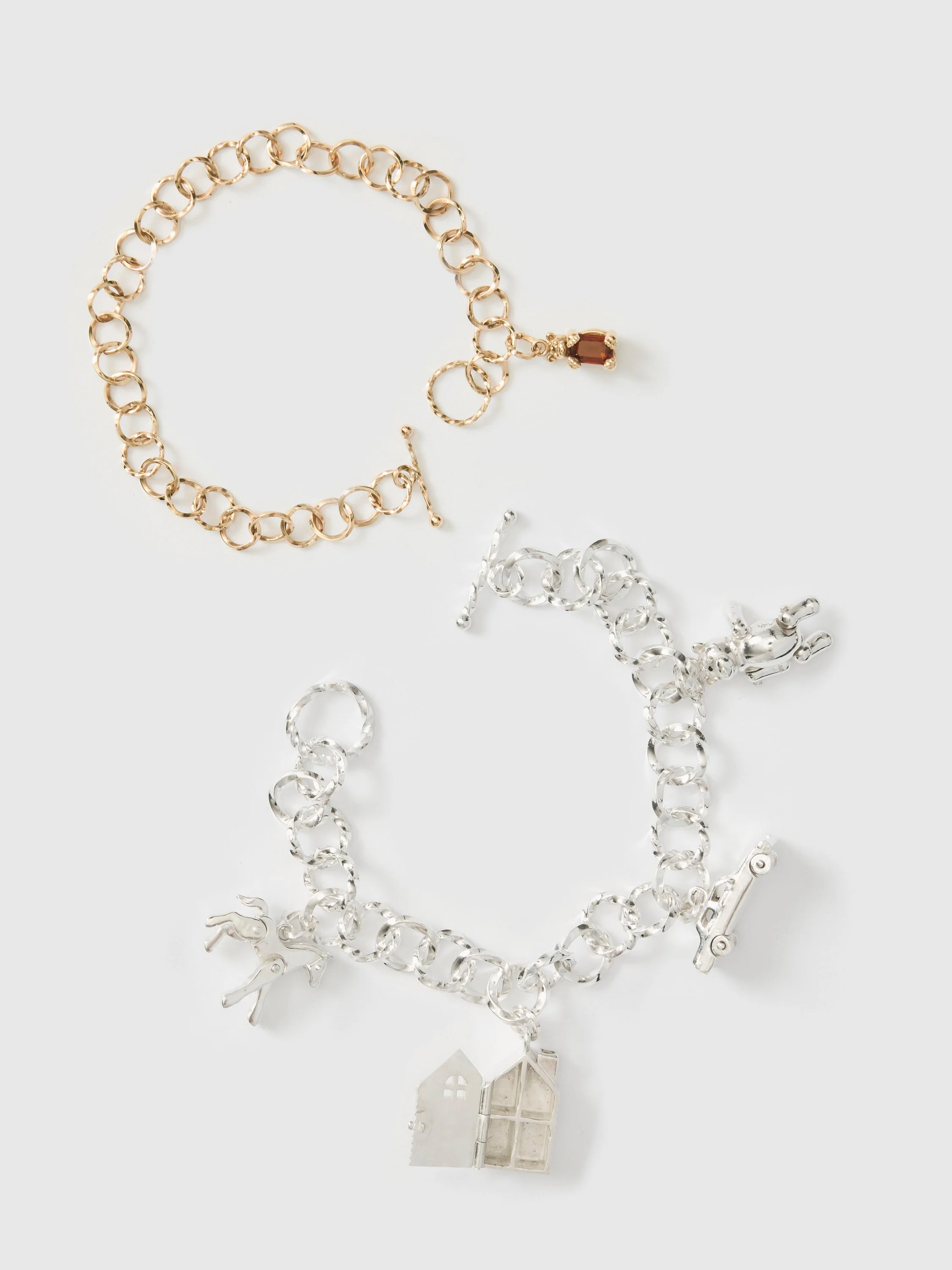 Bracelets and miniature house charms photographed on black fabric