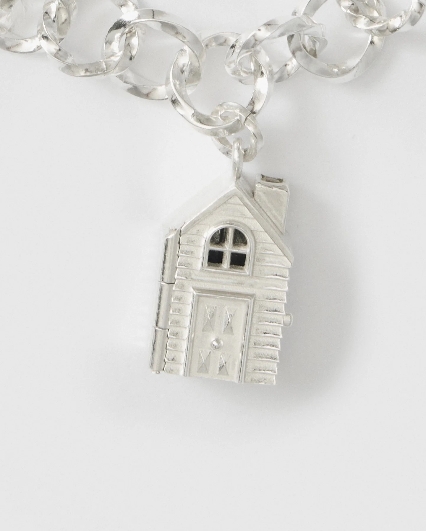 Miniature silver dollhouse charm photographed closed